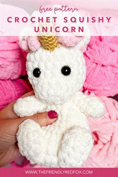 a white crocheted stuffed animal with a gold horn on it's head and text overlay reads free pattern crochet squisy unicorn