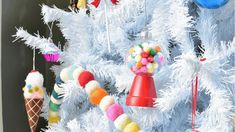 a white christmas tree with ornaments hanging from it