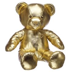 a gold colored teddy bear sitting up against a white background