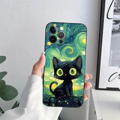 a person holding up a phone case with a black cat on the starry night background