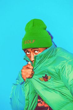 a man wearing a green hat and jacket with the word golf written on it's side