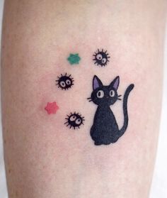 a black cat tattoo on the leg with small spiky dots and stars around it