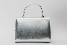 Width: 9" Height: 7" Width: 4.5" Full length of the strap : 41" Timeless Elegance: Ege Silver Leather Handbag" Sleek Silver Leather: Exuding timeless elegance, this handbag is meticulously crafted from premium silver leather for a sleek and sophisticated appearance. Elegant Silver Accents: Enhance your style with tasteful silver accents, adding a touch of refinement to the overall design. Single-Compartment Simplicity: Embrace modern and minimalist appeal with a sleek one-compartment design. Ver Top Handle Evening Bag With Silver-tone Hardware, Elegant Square Flap Bag For Party, Evening Shoulder Bag With Silver-tone Hardware And Top Handle, Luxury Silver Box Shoulder Bag, Elegant Party Flap Bag With Removable Pouch, Rectangular Flap Bag With Silver-tone Hardware For Daily Use, Silver Top Handle Satchel For Party, Evening Satchel With Silver-tone Hardware As Shoulder Bag, Classic Leather Satchel For Party