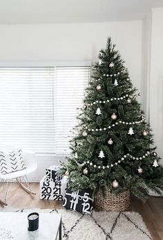 a living room with a christmas tree in the corner and other decorations on the floor