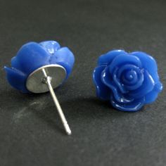 A set of bright royal blue colored resin roses decorate silver plated stud earrings (no nickel) in this pair of handmade earrings that also come with a matching set of silver plated earring backs.Size: 14mm rosesThese earrings are available in a variety of colors! http://etsy.me/1rv1YFVThey are also available as dangle earrings!Bronze - https://www.etsy.com/stumblingonsainthood/listing/106361809Silver - https://www.etsy.com/stumblingonsainthood/listing/113486696If you would like to order a large Blue Round Flower Earrings In Sterling Silver, Nickel-free Blue Flower Earrings, Blue Flower-shaped Sterling Silver Earrings, Blue Flower-shaped Summer Earrings, Blue Flower Stud Earrings, Blue Flower-shaped Resin Earrings, Blue Stud Earrings, Blue Rose, Rose Earrings