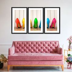 three pictures of colorful high heeled shoes hanging on a wall above a pink couch