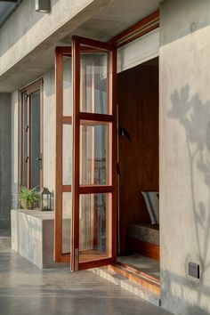 an open wooden door on the outside of a building next to a potted plant