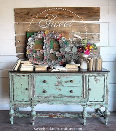 an old dresser is decorated with flowers and succulents