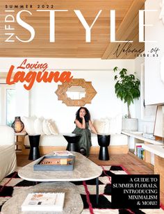 a woman sitting on top of a couch in a living room next to a table