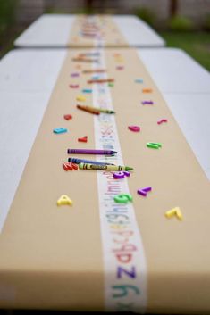 a long table with confetti and markers on the top, along with crayons