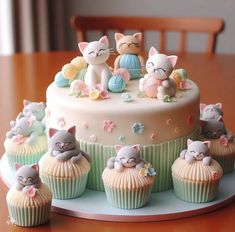 there are many cupcakes that have cats on top of them, and one is decorated in pastel colors