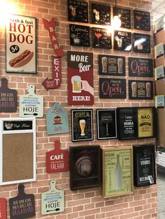 there are many signs on the brick wall in this restaurant that is decorated with beer and hot dogs