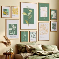 a bed with green sheets and pillows in front of pictures on the wall above it