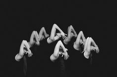 four nude women are laying down on their backs in the middle of a black and white photo