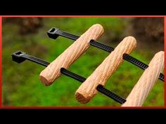 three pieces of wood are being held in the air by two black metal pegs