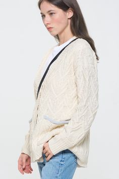 A true classic, this relaxed fit cardigan comes in a thick cable knit. Contrast pockets, a button front and boyfriend body make it the perfect addition to your fall wardrobe. Layer over a timeless white tee or wear open over just about anything. Product Details Material: 70% Polyester, 30% Acrylic. Fit: Relaxed boyfriend fit. Body length: 24" from shoulder to hem (size Small). Fabric: Thick cable knit. Features: Button front, v-neckline, boyfriend body, weaved cable knit design, contrast trimmed Casual Cotton Sweater Coat With Cable Knit, White Cardigan With Pockets For Layering, Oversized White Sweater Coat With Pockets, White Cable Knit Outerwear For Work, White Oversized Sweater Coat With Pockets, White Cotton Cable Knit Cardigan, Cozy White Cardigan With Pockets, Casual White Cable Knit Sweater Coat, Casual Relaxed Fit Cable Knit Cardigan