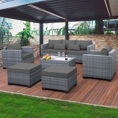 an outdoor living area with grey wicker furniture