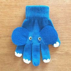 an elephant mitt made out of blue wool with white clouds on the ears and feet