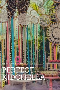 a table topped with cakes and cupcakes under lots of colorful paper streamers