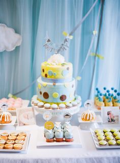 a table topped with lots of cakes and cupcakes