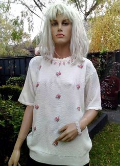 Absolutely adorable subtly feminine loose knitted sweater with delicate embroidery flowers. Features jagged neckline and drop shoulders give a casual elegance to this funky hipster white knit sweater.  This floral embroidery short sleeve sweater looks like from the mid-50s style, but the label's instructions with the care tag show us that the sweater is from the 70s or early 80s. Acrylic fabric base with cable knit details in a soft, cozy white color, great spring, summer sweater. This mod sweat Feminine White Crew Neck Sweater, Cream Crew Neck Sweater With Floral Embroidery, Spring Crew Neck Feminine Sweater, Cream Floral Embroidered Crew Neck Sweater, Spring Feminine Crew Neck Sweater, Feminine Spring Crew Neck Sweater, White Crew Neck Sweater For Daywear, Spring Daywear Sweater With Crew Neck, Spring Daywear Crew Neck Sweater