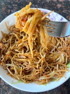 a white plate topped with shredded cheese and a fork sticking out of the top of it