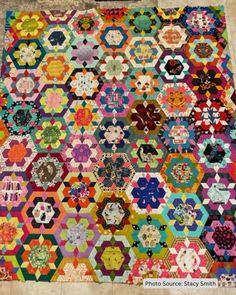 an old quilt with many different colors and patterns on the front, one is multicolored