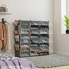 an organized closet with shoes and handbags hanging on the wall next to a rug