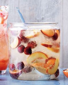 a jar filled with ice and fruit on top of a table