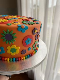 there is a colorful cake with flowers on the frosting and icing, ready to be eaten