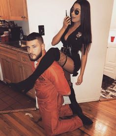 a man kneeling on the floor next to a woman in tights and boots while she talks on her cell phone