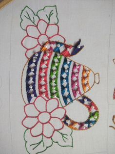 a close up of a embroidery on a piece of cloth with flowers and fish in it