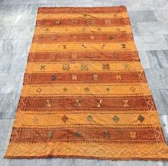 an orange and brown rug on the floor