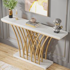 a modern console table with marble top and gold metal legs, in a living room