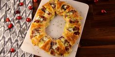 a white cutting board topped with pastry on top of a wooden table next to cranberries