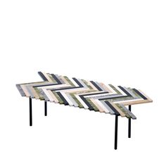 a coffee table made out of strips of wood and black metal legs, with a chevron pattern on the top