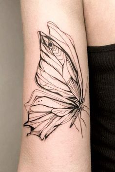 a black and white butterfly tattoo on the arm