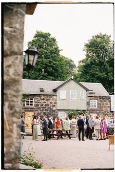 a group of people standing in front of a stone building