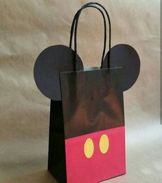 a paper bag with mickey mouse ears on it's side and eyes painted red, yellow, and black