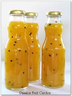 three jars filled with liquid sitting on top of a table