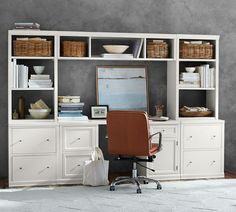 an office area with a chair, desk and bookcases in white painted wood