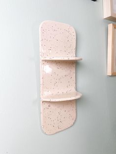 a white wall mounted shelf next to a clock