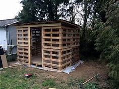 a building made out of wooden pallets in the yard