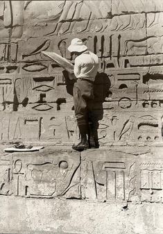 a man standing in front of an egyptian steet with writing on it's side