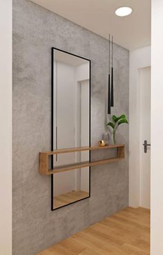 an empty room with a mirror, shelf and vase on the wall next to it