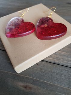 Beautiful natural rose petals in heart resin earrings. Half heart earrings with half rose petals, half glittering red.. Hues of amber red paired with golden metals make these natural earrings boldly colorful. Ruby red earrings with handmade resin heart pendants with real dried rose petals ♥ Be sure to check out the RED EARRINGS section at EarringsbyLCreations for all beautiful red colored earrings available! https://www.etsy.com/shop/EarringsByLCreations?section_id=28420977 Made with quality mat Resin Hearts, Natural Earrings, Real Flower Earrings, Heart Resin, Half Heart, Colored Earrings, Dried Rose Petals, Nature Earrings, Heart Pendants