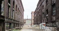 an alley way with graffiti on the walls and brick buildings in the backround