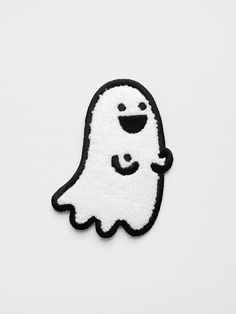 a black and white patch with a ghost on it's back, in front of a white background