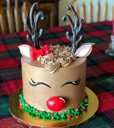 a decorated cake on a table with red nose and antlers