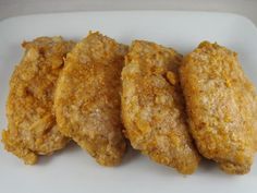 four pieces of fried chicken on a white plate